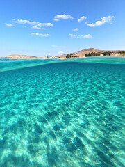Underwater split photo of paradise exotic island beach with crystal clear turquoise sea in exotic destination island