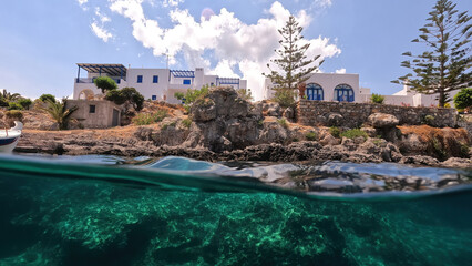 Underwater split photo of small bay and pituresque village of Avlemonas with emerald crystal clear sea in island of Kythira, Ionian, Greece