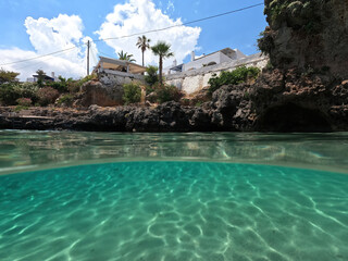 Obraz premium Underwater split photo of small bay and pituresque village of Avlemonas with emerald crystal clear sea in island of Kythira, Ionian, Greece