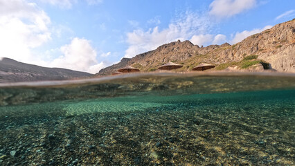 Underwater split photo of paradise exotic island beach with crystal clear turquoise sea in exotic destination island
