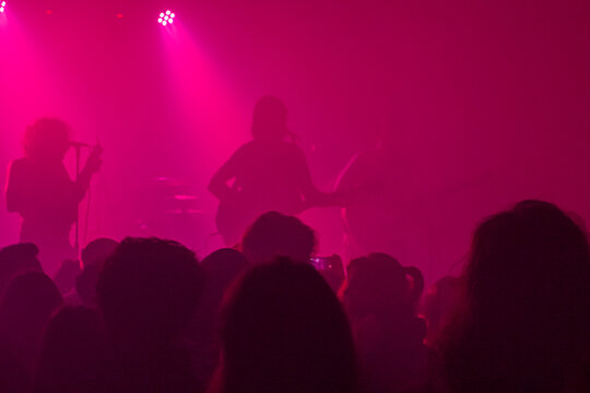 Concierto, baile, luces rosa fucsia