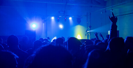 Concierto música, gente bailando, luz azul.