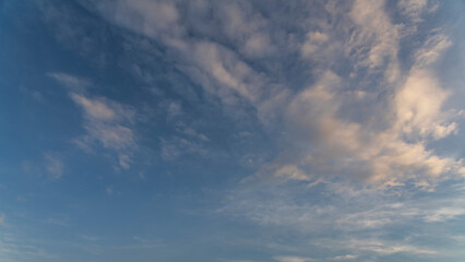 Fantastic bright clouds in the sunset sky. 
Sky background.