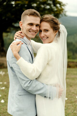 Fototapeta premium young wedding couple gently hugging after the wedding ceremony in the mountains. beautiful wedding day