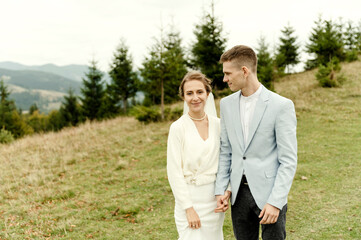 young wedding couple gently hugging after the wedding ceremony in the mountains. beautiful wedding day