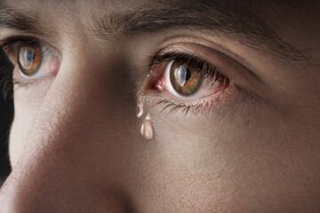 Closeup of young crying man eyes with a tears - Powered by Adobe