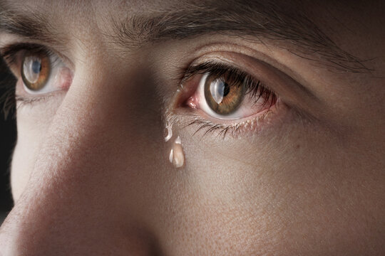 Closeup of young crying man eyes with a tears