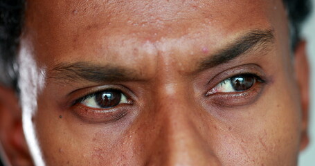 Fototapeta premium African man eyes thinking deeply, macro close-up of pensive thoughtful black person pondering solution