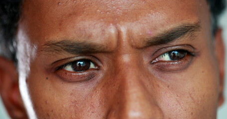 Fototapeta premium African man eyes thinking deeply, macro close-up of pensive thoughtful black person pondering solution