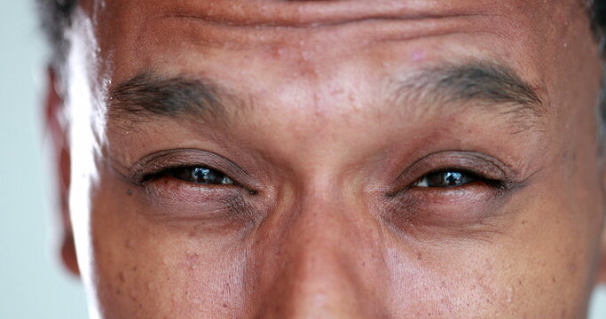 African man eyes squinting. Close-up black guy closing eyes squint