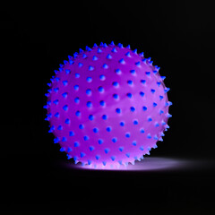 Purple ball with blue spikes isolated and glowing on black background