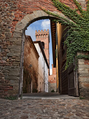 Montecarlo, Lucca, Tuscany, Italy: view of the old town gate with the narrow alley and the bell tower of the ancient church - obrazy, fototapety, plakaty