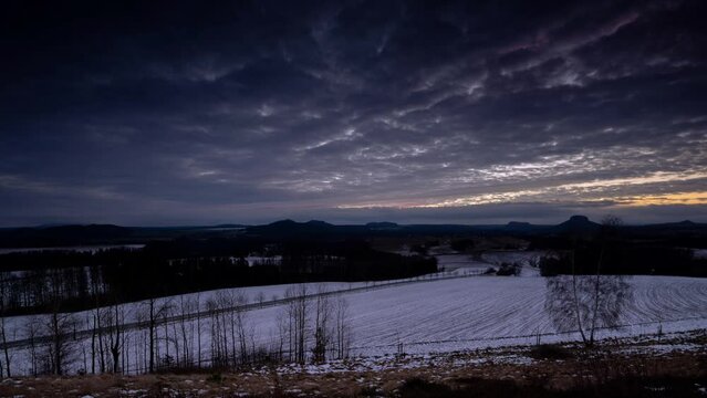 Sonnenuntergang im Elbsandsteingebirge: Auf den Wiesen liegt Schnee. Es ist Winter und die Luft besonders klar. So kann der Blick auf die zauberhaft Landschaft der S&auml;chsischen Schweiz genossen werden.
