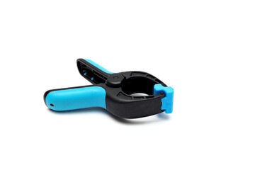 Plastic spring clamp isolated on white background. Clamping equipment. Working hand tool. Closeup.