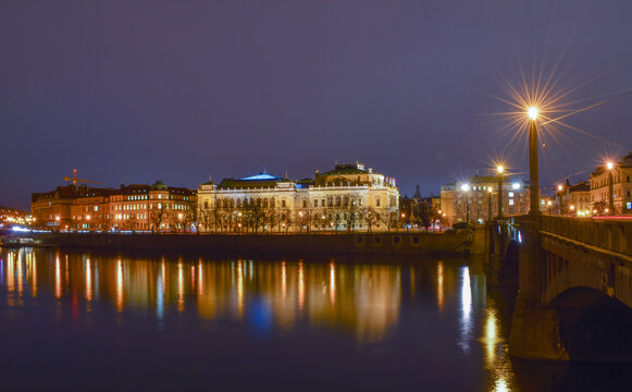 Night city landscape, reflection of street lights in the river, bridge