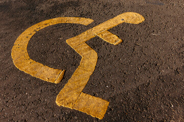 Disabled parking. Accessible parking spot. Blue badge. Yellow wheelchair sign on the ground