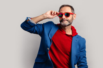 Stylish senior man peeking through sunglasses