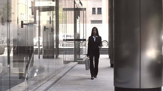 Business woman carrying a silver briefcase walking