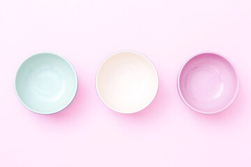 Obraz premium Empty color bowls isolated on pink background. Top view.
