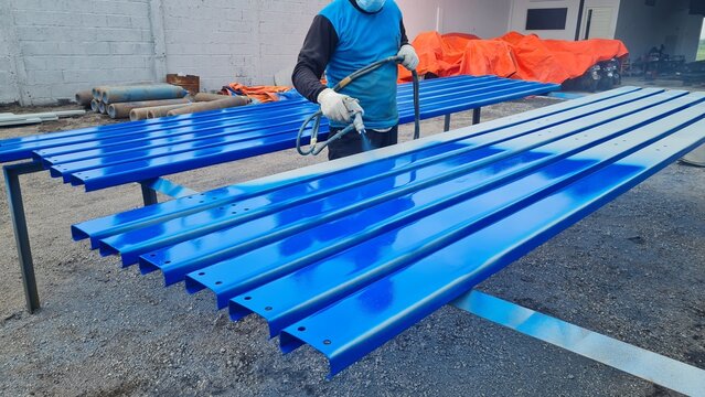 Construction Worker Is Painting Steel Construction With Spray Paint Tool In Workshop