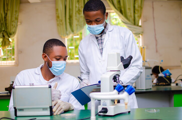 handsome lab technicians or scientists working in laboratory taking documentation