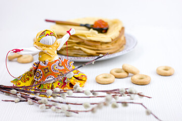 Background with pancakes, textile doll, sushki, pussy-willow and spoon with caviar on white for Maslenitsa festival.