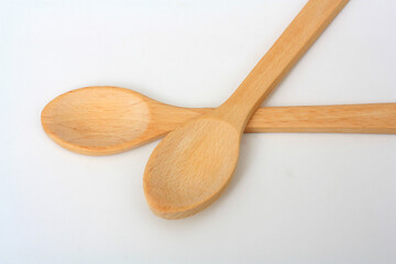 Two wooden spoons on the white background. Kitchen equipment.