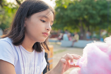 Obraz premium Adorable little sisters eating candy-floss outdoors at summer