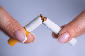Closeup woman hands with broken cigarette. Stop smoking, quit smoking or no smoking concept