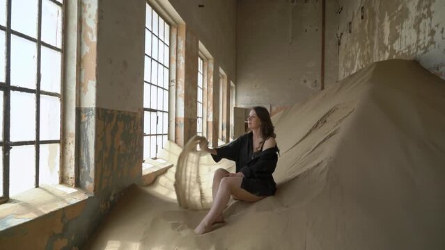 Young woman in black shirt and underwear in abandoned building posing in room.