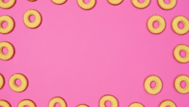 Round biscuit cookies make interesting frame for text on vibrant pink theme. Stop motion flat lay