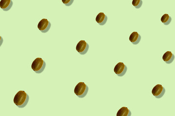 Colorful fruit pattern of fresh kiwi on light green background with shadows. Top view. Flat lay. Pop art design