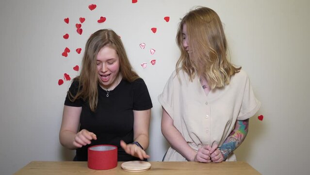 girl receives as a gift a red condom in a red box