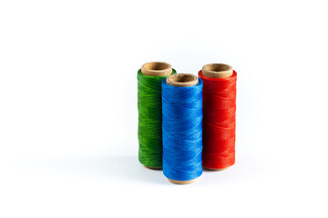 A skein of red, blue and green thread. Coils of colored threads on a white background. Waxed sewing thread for leather goods.