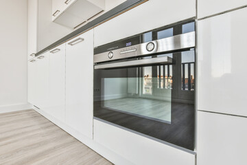 Interior design of an empty kitchen with a white kitchen set and a built-in oven