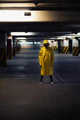 Woman in raincoat standing in a parking lot