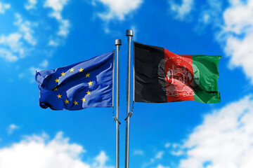 Flags of European Union and Afghanistan on the wind against blue sky