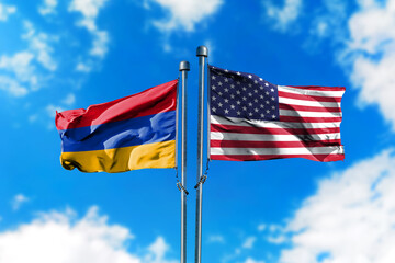 Flags of Armenia and America on the wind against blue sky