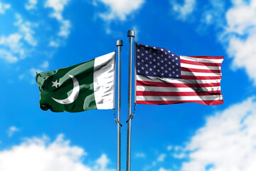 Flags of Pakistan and America on the wind against blue sky