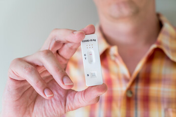 Man holding Covid-19 rapid antigen test cassette with negative result of rapid diagnostic test. Self-testing kit