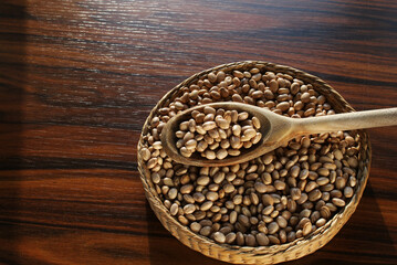 Carioca beans spoon. Beans in a wooden spoon on the top of beans basket. Space for text in left.