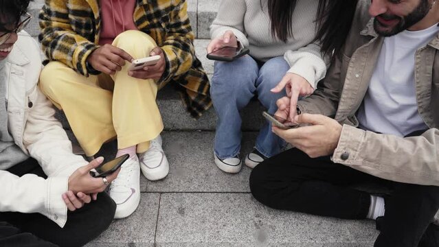 Close up of people hands sharing content on social media network with smartphone. Friends group having fun using mobile smart phone. Millennials addicted online with cellphone