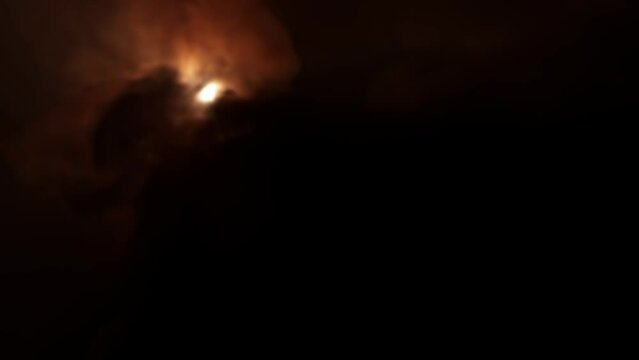 Thick puffs of black smoke make it impossible to see a glowing unidentified object that flies in the background.