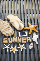 Fototapeta na wymiar The word 'summer', a starfish and a digital camera