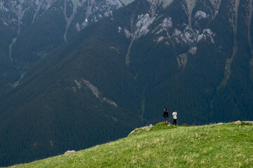 Fototapeta na wymiar Tourist is walking on green valley with beautiful mountains background.