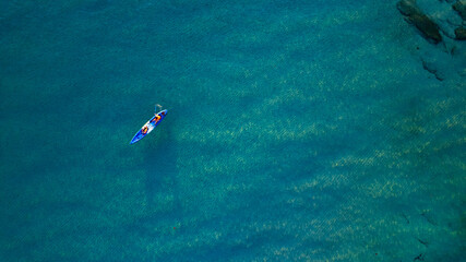 Aerial view of a kayak in the blue sea .Woman kayaking She does water sports activities.