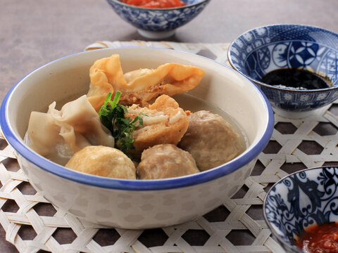 Bakso Malang, Meatball Soup with Various Side Dish like Tofu Fried Shiumay, or Bakso Goreng. Served on the Table with Sambal, Soysauce, and Tomato Sauce.
