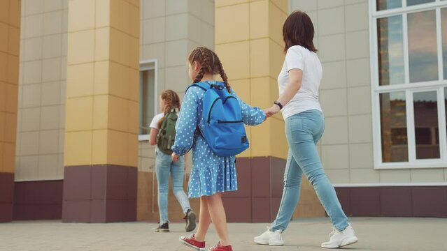 back to school. mom and daughter a go hand in hand to school for lesson. education support training concept. lifestyle child walk to school with a backpack. daughter mom rush to school. family day