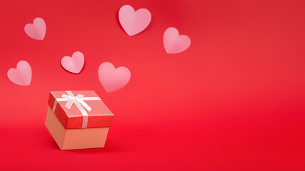 Gift and hearts on red background