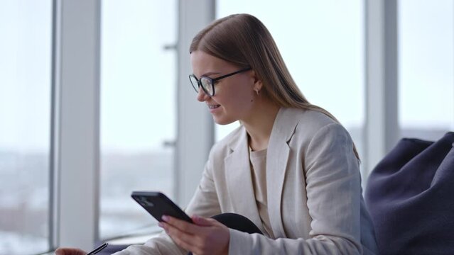 Beautiful young business wonan working with phone. Office business lady smartphone working.